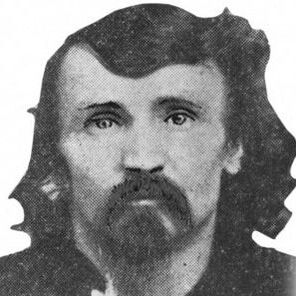 Black and white photo of Packer, a white man with dark wavy hair and matching mustache and goatee